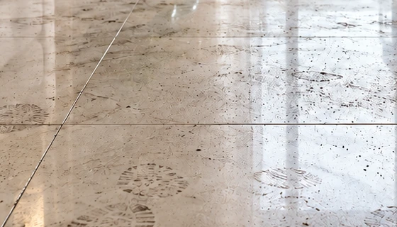 Household tile floor with everyday dust and light marks before cleaning.